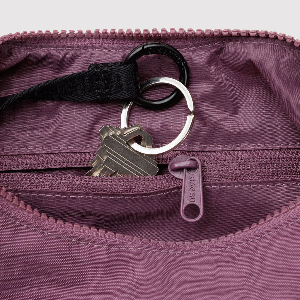 Purple bag with a key and keychain attached, showing a close-up of the zipper and fabric texture.