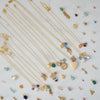 Gold necklaces with various pendants on a light background