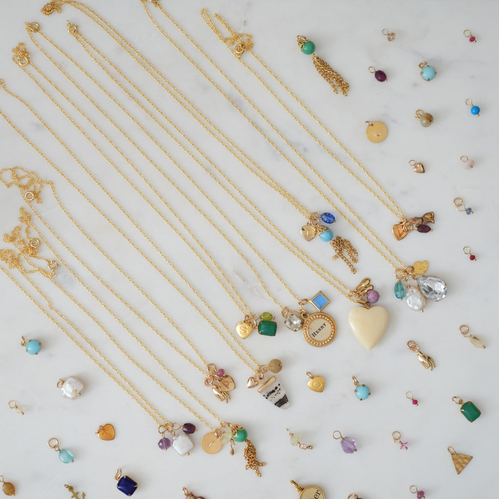 Gold necklaces with various pendants on a light background