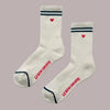 White socks with red hearts and 'Le Bon Shoppe' branding on a pink background