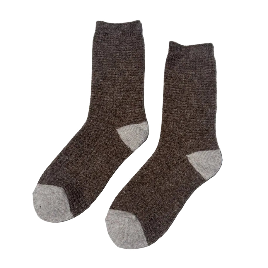 Pair of brown socks with gray toes and heels on a light gray background