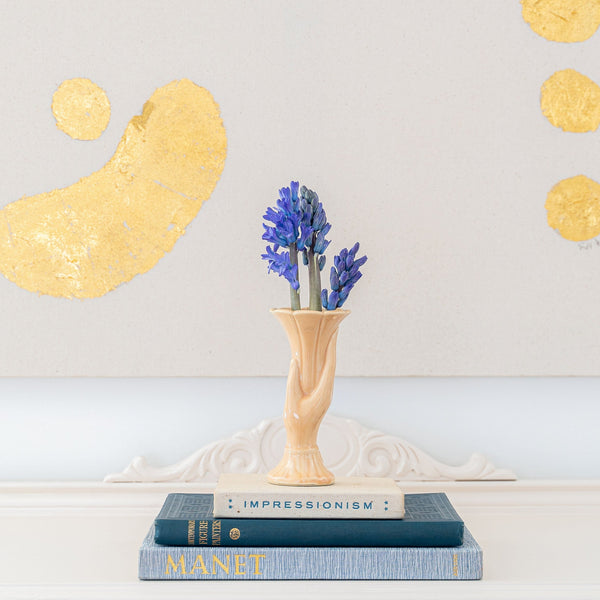 Vintage McCoy hand vase in cream holding Hyacinth with a lovely art backdrop.