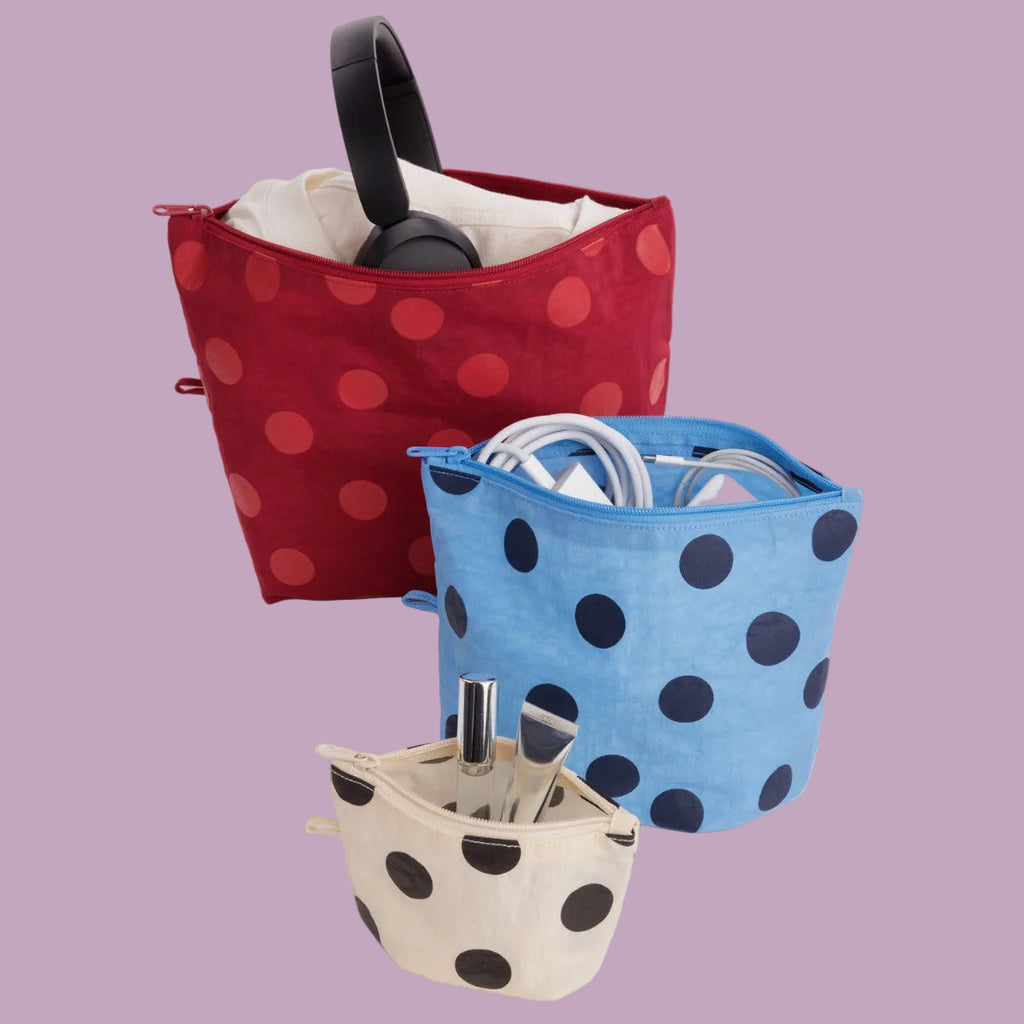 Three polka dot bags in red, blue, and beige on a white background