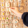 Person selecting charms from a display rack in Golden Rule Gallery