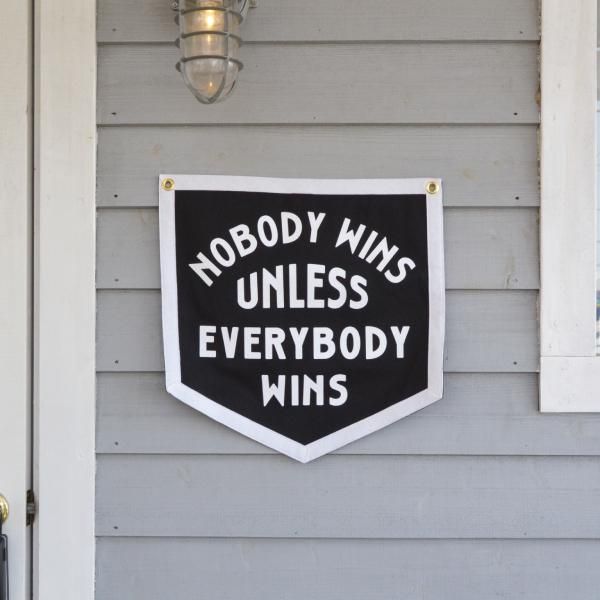 Black and white sign with motivational quote on a house exterior