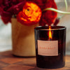 Candle Labeled Ojai Nuit lit by Flowers
