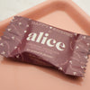 Package of 'alice' mushroom chocolate on a beige surface