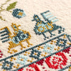Close-up of cross-stitched design with geometric patterns on fabric