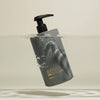 Shampoo bottle labeled 'Element Brooklyn' with a pump mechanism, partially submerged in water on a beige background.