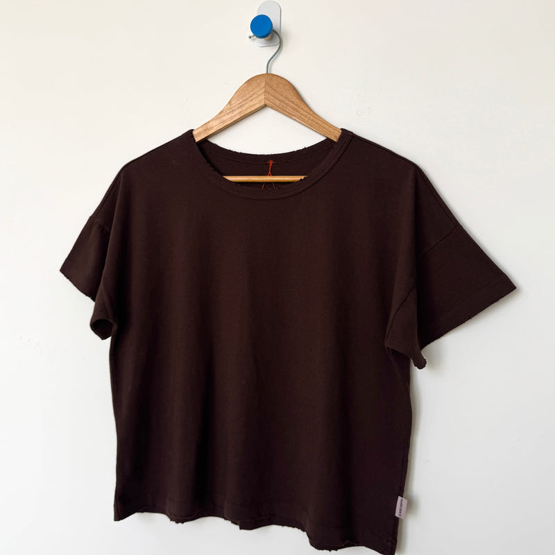 Le Bon Shoppe brown t-shirt on a wooden hanger against a white background