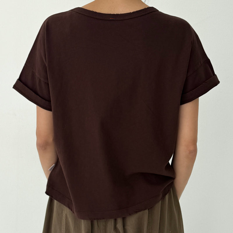 Brown t-shirt worn by a person on a white background