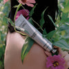 Model holding Jasmine Damask Rose Rich Cream by Flamingo Estate with Flowers