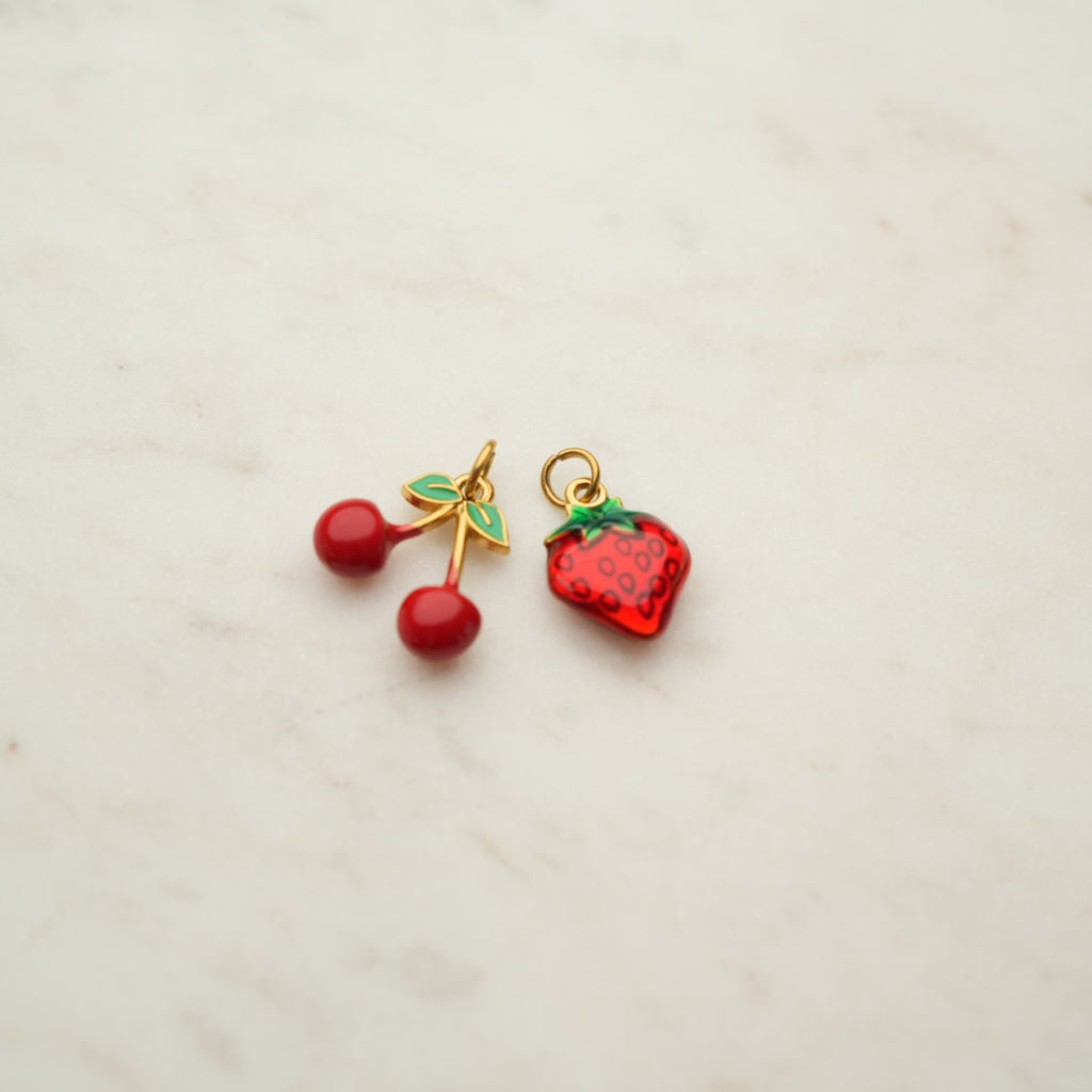 Two colorful fruit charms at Golden Rule Gallery
