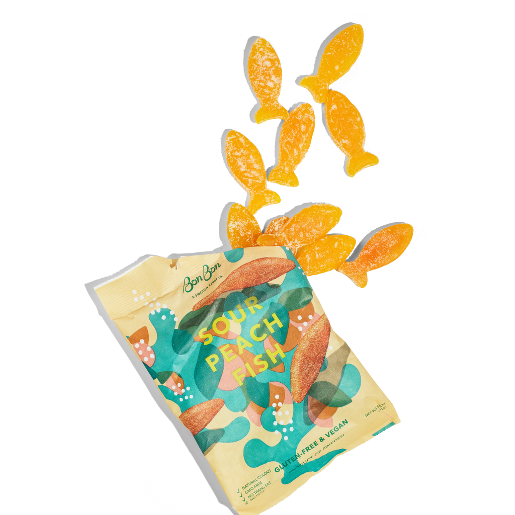 Sour Patch Fish gummy candy package with gummy fish on a white background