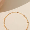 Gold chain bracelet on a beige background