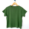 Green t-shirt by Le Bon Shoppe on a wooden hanger against a white background