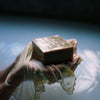 Hands Holding Flamingo Estate's Green Goddess Soap Bar Brick