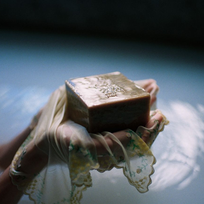 Hands Holding Flamingo Estate's Green Goddess Soap Bar Brick