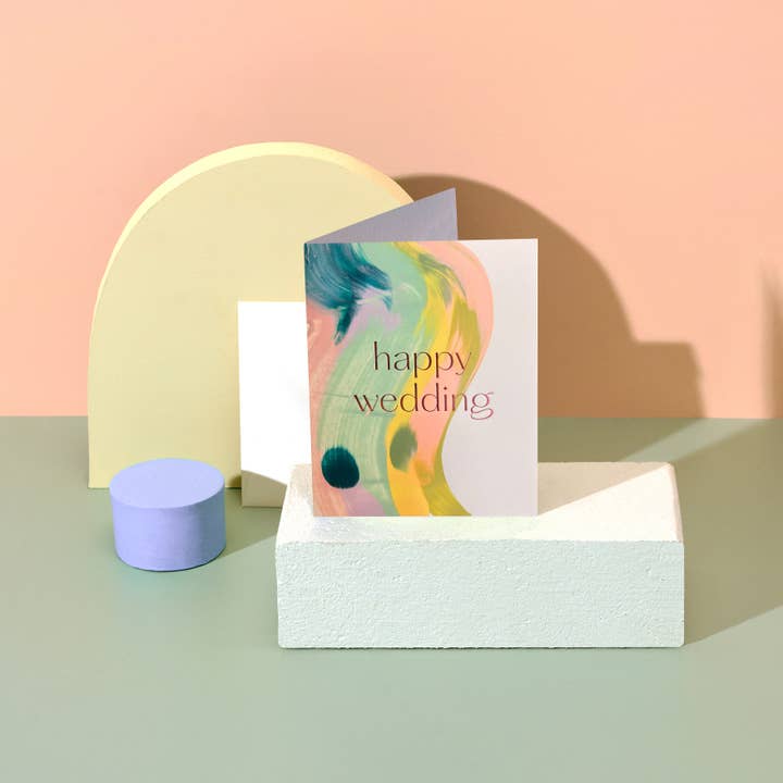 Greeting card with 'happy wedding' text on a pastel background