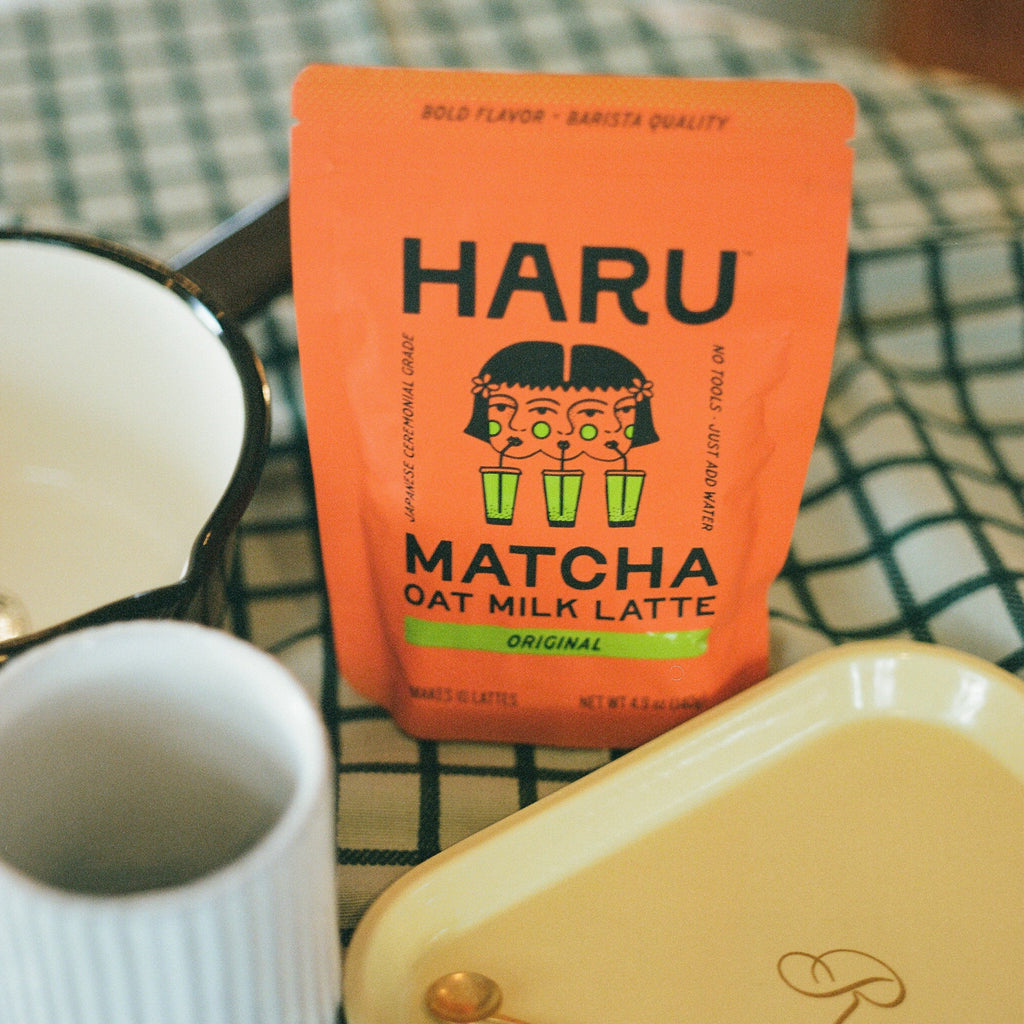 Haru Matcha Oat Milk Latte package on a checkered tablecloth with a white mug and yellow container.
