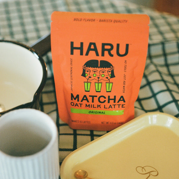 Haru Matcha Oat Milk Latte package on a checkered tablecloth with a white mug and yellow container.