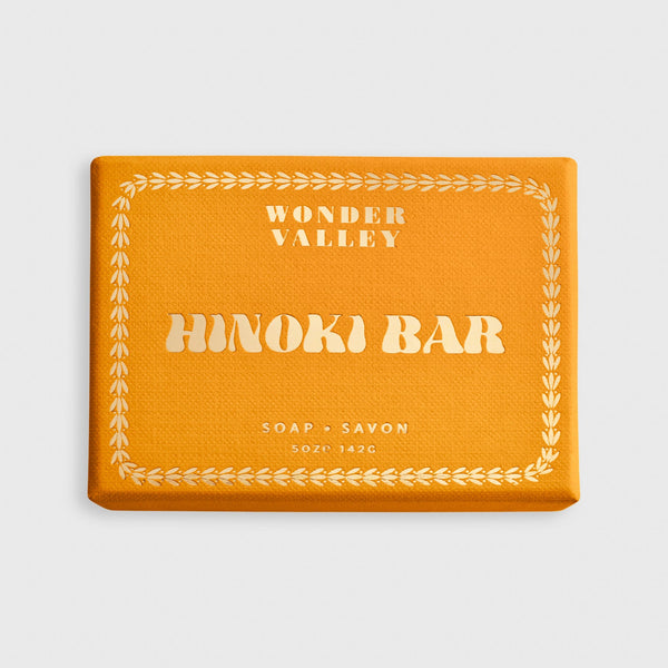 Orange soap bar with 'Wonder Valley Hinoki Bar' text on a light gray background