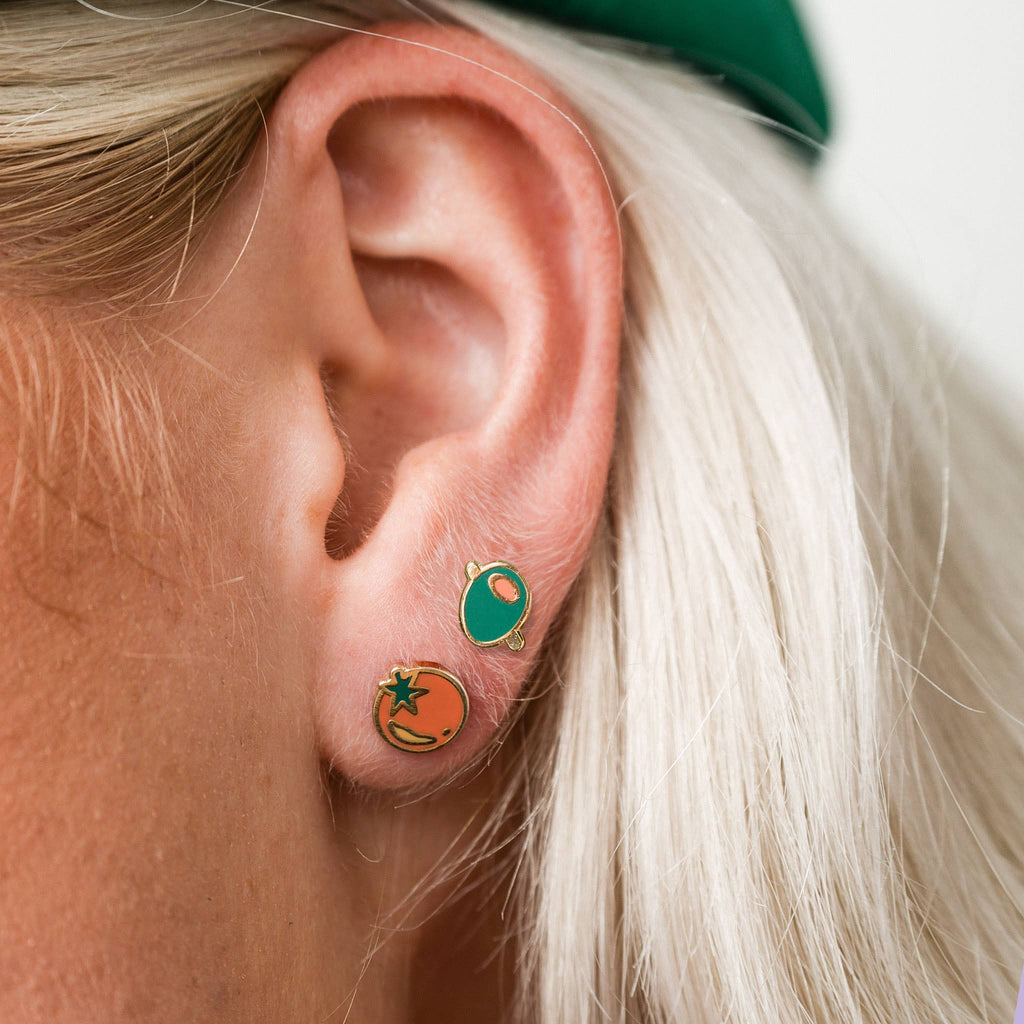 Close-up of an ear wearing small olive stud earrings