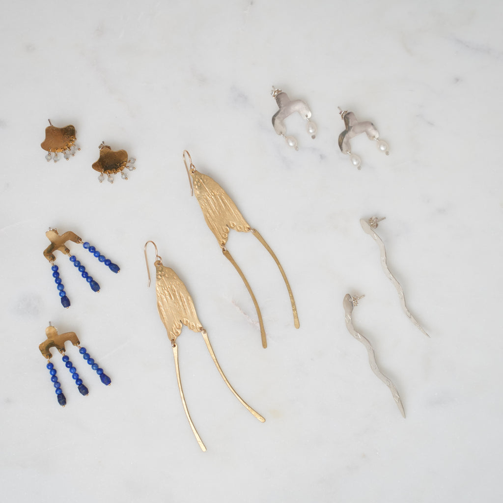 Collection of gold and silver jewelry on a marble surface