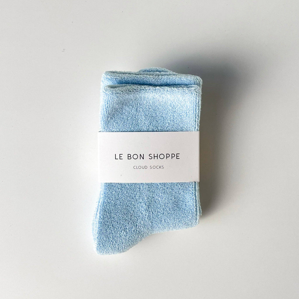 Folded light blue Le Bon Shoppe Cloud socks with a white label on a gray background