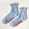 Pair of light blue socks with red text on a white background