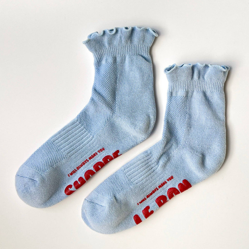 Pair of light blue socks with red text on a white background