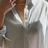 Close-up of a person wearing a striped shirt with a blurred background