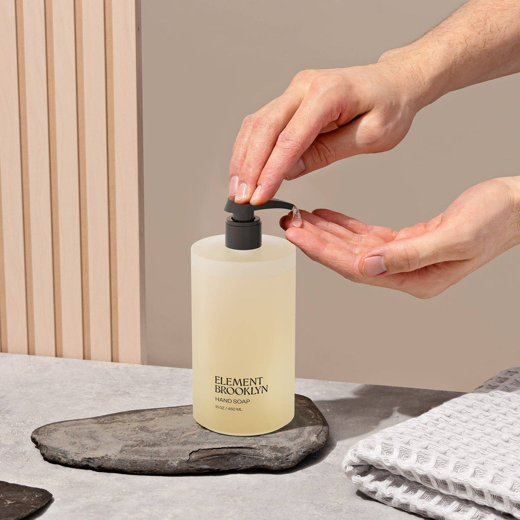 Person using hand soap pump bottle by Element Brooklyn on bathroom counter 