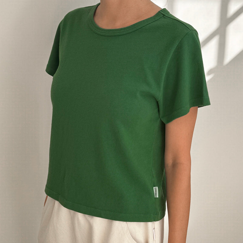 Green Le Bon Shoppe t-shirt worn by a person on a plain background