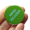 Green button with 'MIND READER' text held in a hand against a white background