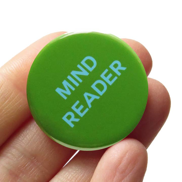 Green button with 'MIND READER' text held in a hand against a white background