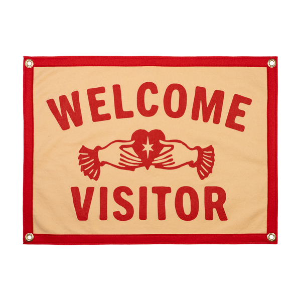 Fabric sign with 'Welcome Visitor' text and a red border on a beige background