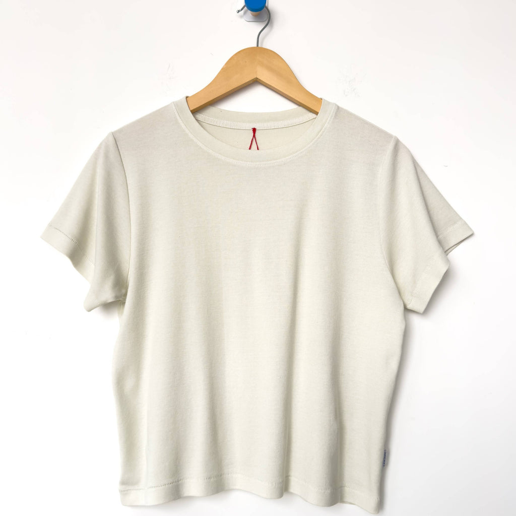 Chalk Noel Short Sleeve Tee Shirt on a Hanger by Le Bon Shoppe
