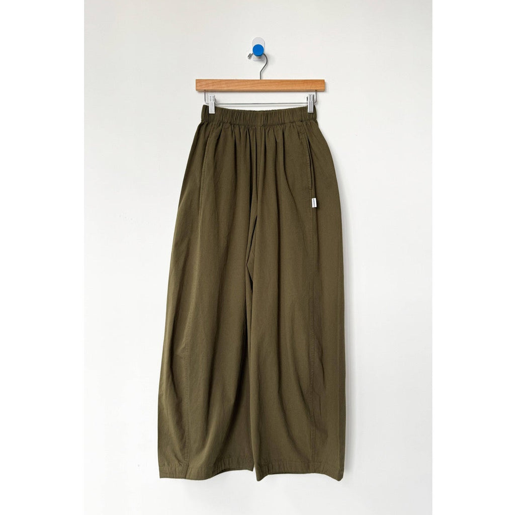 Olive green wide-leg pants on a hanger against a white background