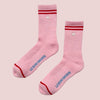 Pink socks with red accents and 'LE BON SHOPPE' branding on a light pink background