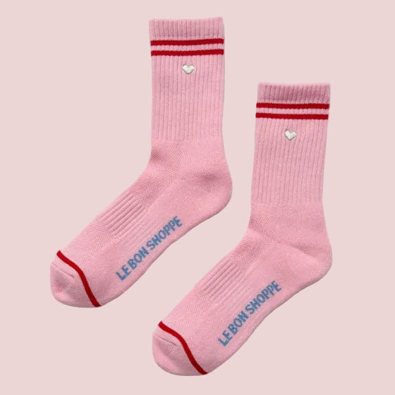 Pink socks with red accents and 'LE BON SHOPPE' branding on a light pink background