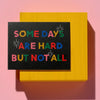 Motivational card with colorful text on a yellow frame against a pink background
