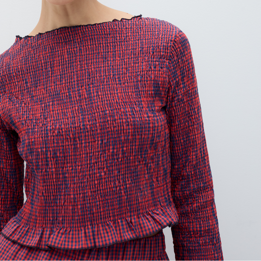 Red and blue checkered blouse on a plain background