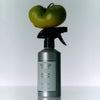 Spray bottle labeled 'Flamingo Estate' with a green tomato on top against a white background