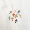 Assorted colorful cross-shaped pendants on a white background