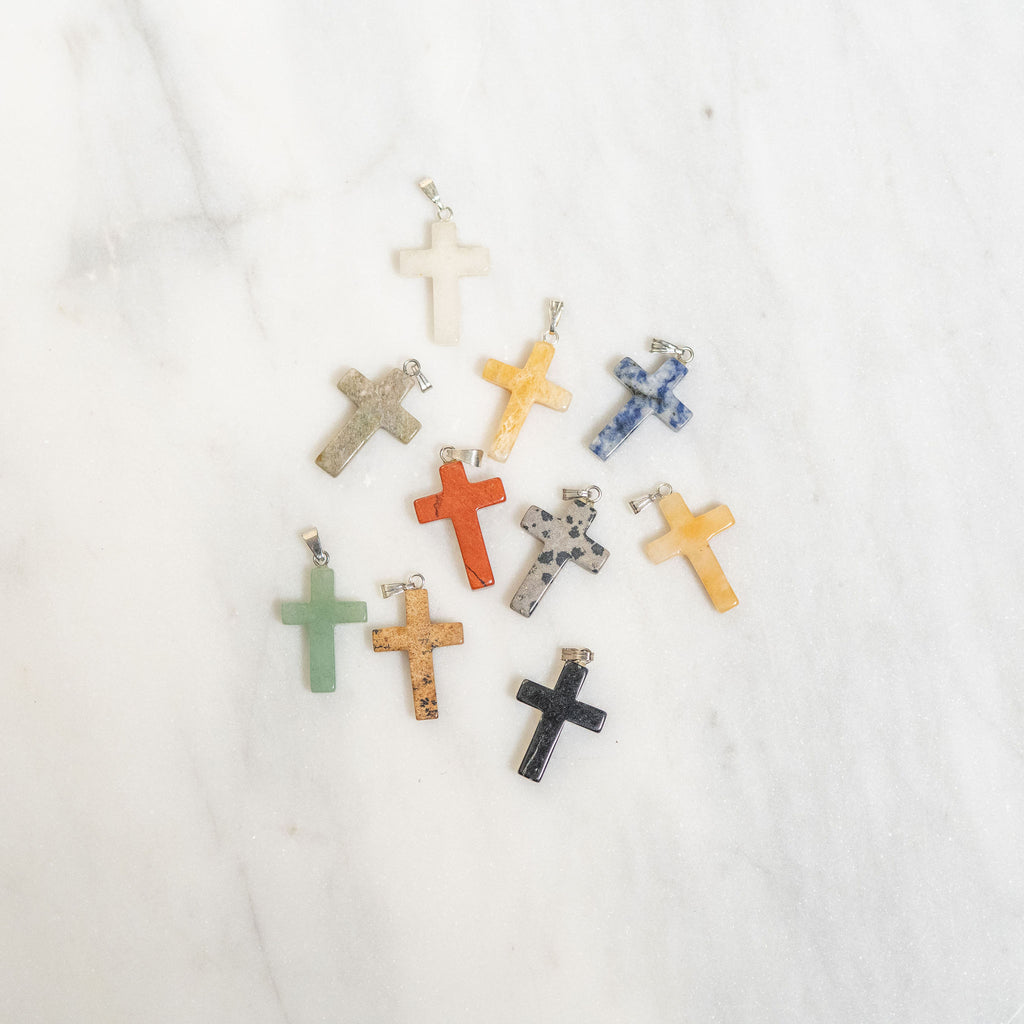Assorted colorful cross-shaped pendants on a white background