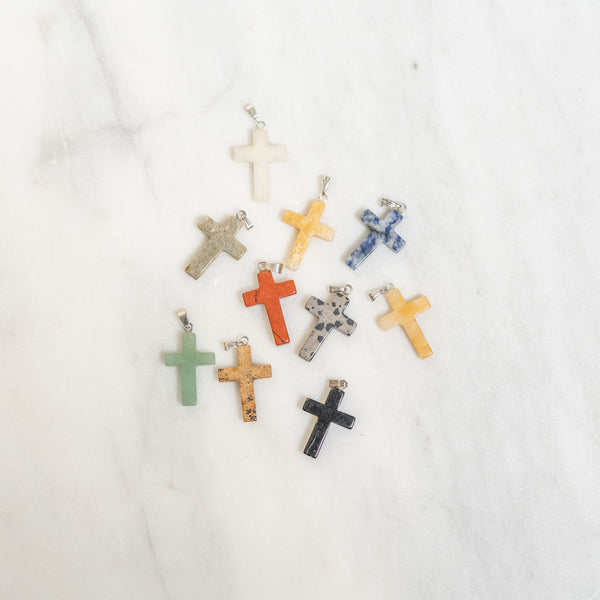 Assorted colorful cross-shaped pendants on a white background