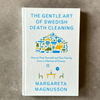 Book titled 'The Gentle Art of Swedish Death Cleaning' by Margareta Magnusson on a gray background