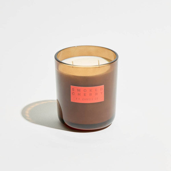 Candle with a 'Smoked Cherry' label on a light gray background