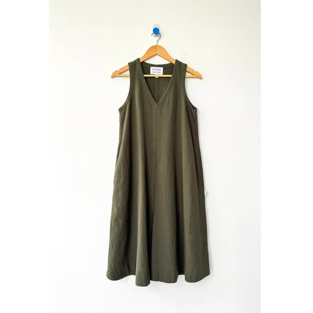 Green sleeveless dress on a hanger against a white background